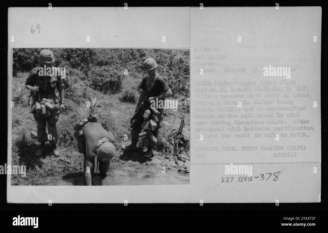 Amerikanische Marines reinigen Wasser für die Nachversorgung im Feld während der Operation Adair in Vietnam. Lance Corporal Steve A. Militar und ein nicht identifizierter Marine können beobachtet werden, wie er das Wasser mit Halazon-Reinigungstabletten behandelt, um sicherzustellen, dass es sicher getrunken werden kann. Das Foto wurde am 18. Juni 1967 von Michael D. Zemads aufgenommen. Stockfoto