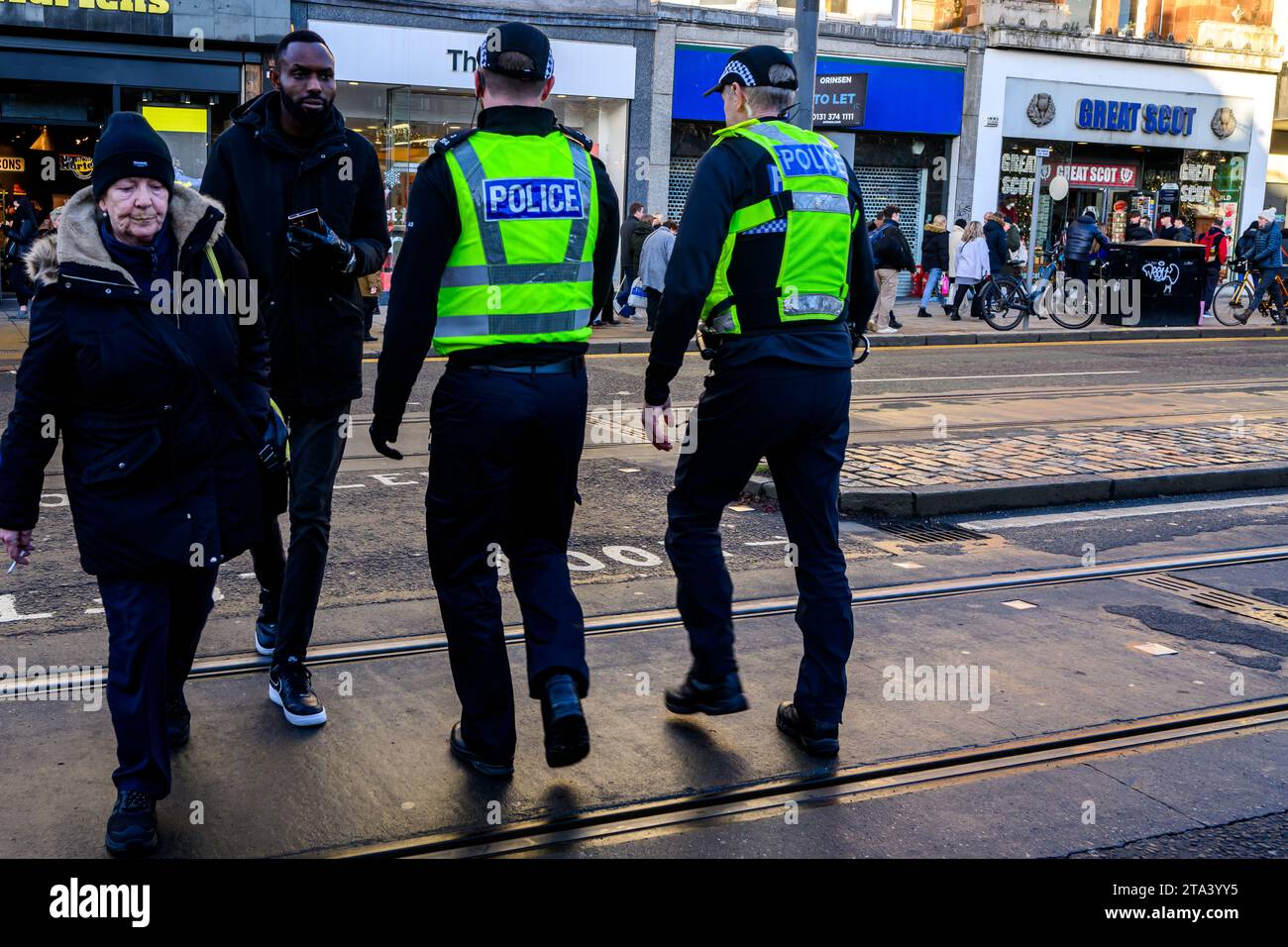 Polizei von Schottland Polizeibeamte benutzen Eine Fußgängerüberfahrt, während sie Princes Street, Edinburgh, Großbritannien, patrouillieren Stockfoto