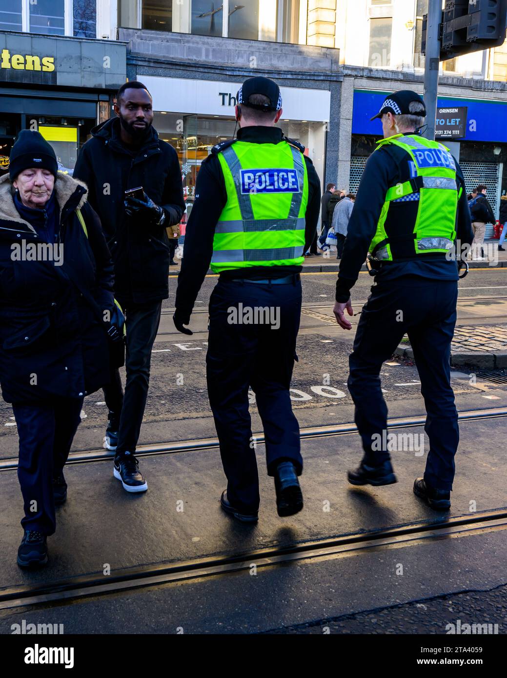 Polizei von Schottland Polizeibeamte benutzen Eine Fußgängerüberfahrt, während sie Princes Street, Edinburgh, Großbritannien, patrouillieren Stockfoto