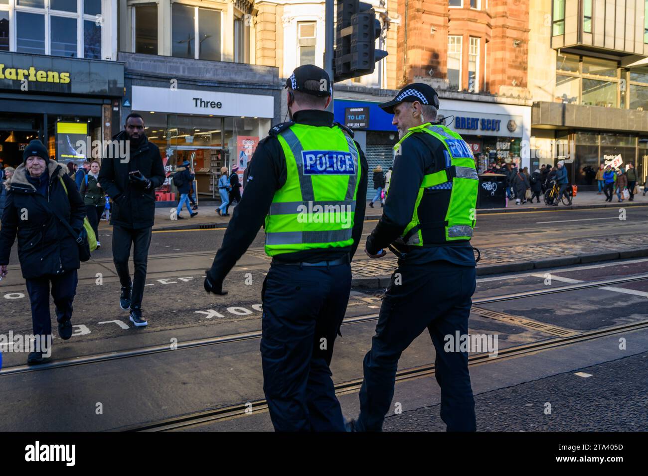 Polizei von Schottland Polizeibeamte benutzen Eine Fußgängerüberfahrt, während sie Princes Street, Edinburgh, Großbritannien, patrouillieren Stockfoto