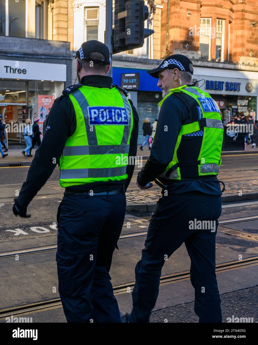 Polizei von Schottland Polizeibeamte benutzen Eine Fußgängerüberfahrt, während sie Princes Street, Edinburgh, Großbritannien, patrouillieren Stockfoto