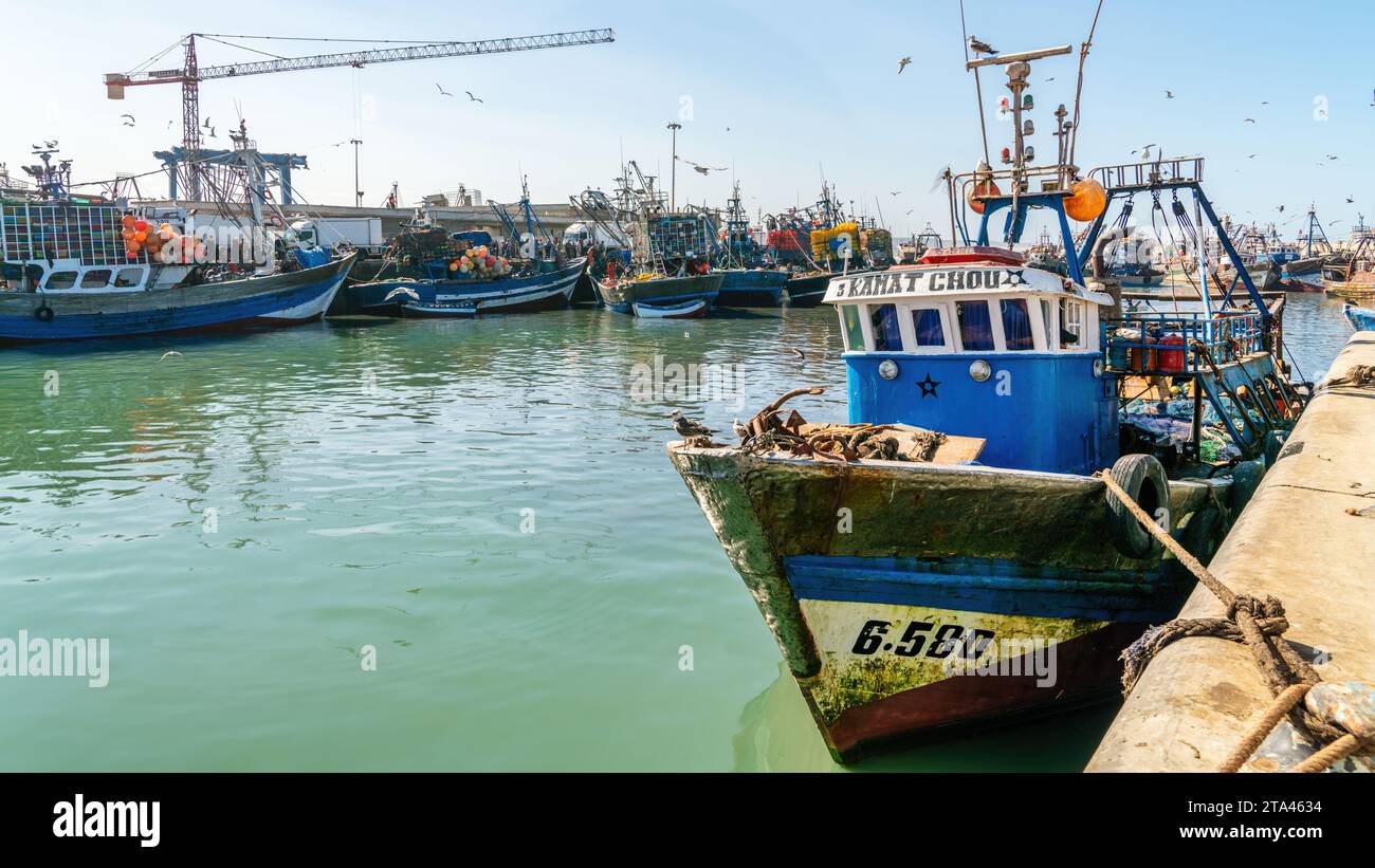 Essaouira, Marokko - 17. September 2022: Traditionelles blaues Fischerboot legt im Hafen von Essaouira an. Fischerboote säumen den Hafen und bringen den Tag ein. Stockfoto