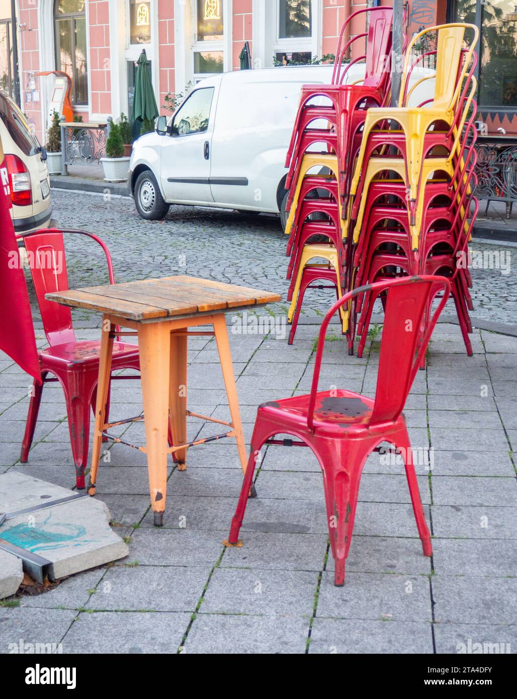 Alte schäbige Tische und Stühle in einem Café. Es gibt keine Gäste im Café auf der Straße. Alte Möbel auf der Straße. Stockfoto