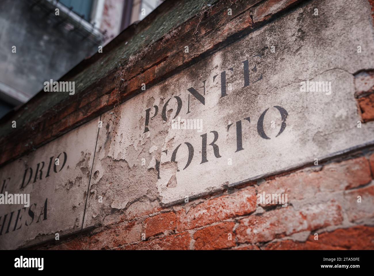 Vintage-rötlich-braune Ziegelwand mit verblasstem „Ponele a Forno“-Schild – Kollektion Venice, Italy Stockfoto