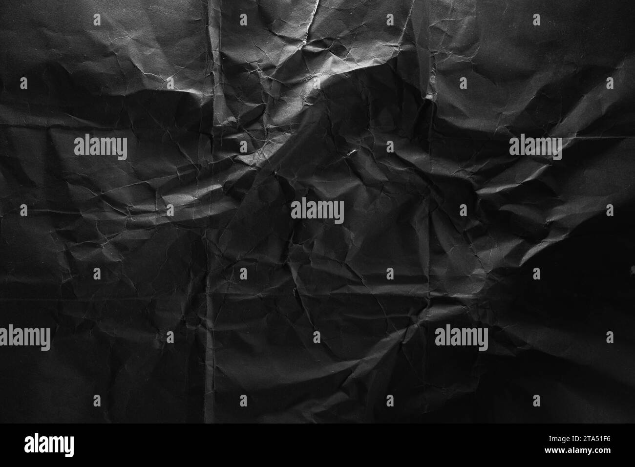 Schwarze zerknitterte Papiertextur in hellem Hintergrund Stockfoto