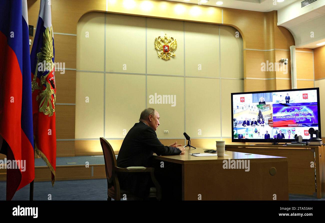 Sotschi, Russland. November 2023. Der russische Präsident Wladimir Putin, links, hört per Videokonferenz der Plenarsitzung des Russischen Weltrates von seiner Residenz am Schwarzen Meer am 28. November 2023 in Sotschi, Russland. Quelle: Mikhail Klimentyev/Kreml Pool/Alamy Live News Stockfoto