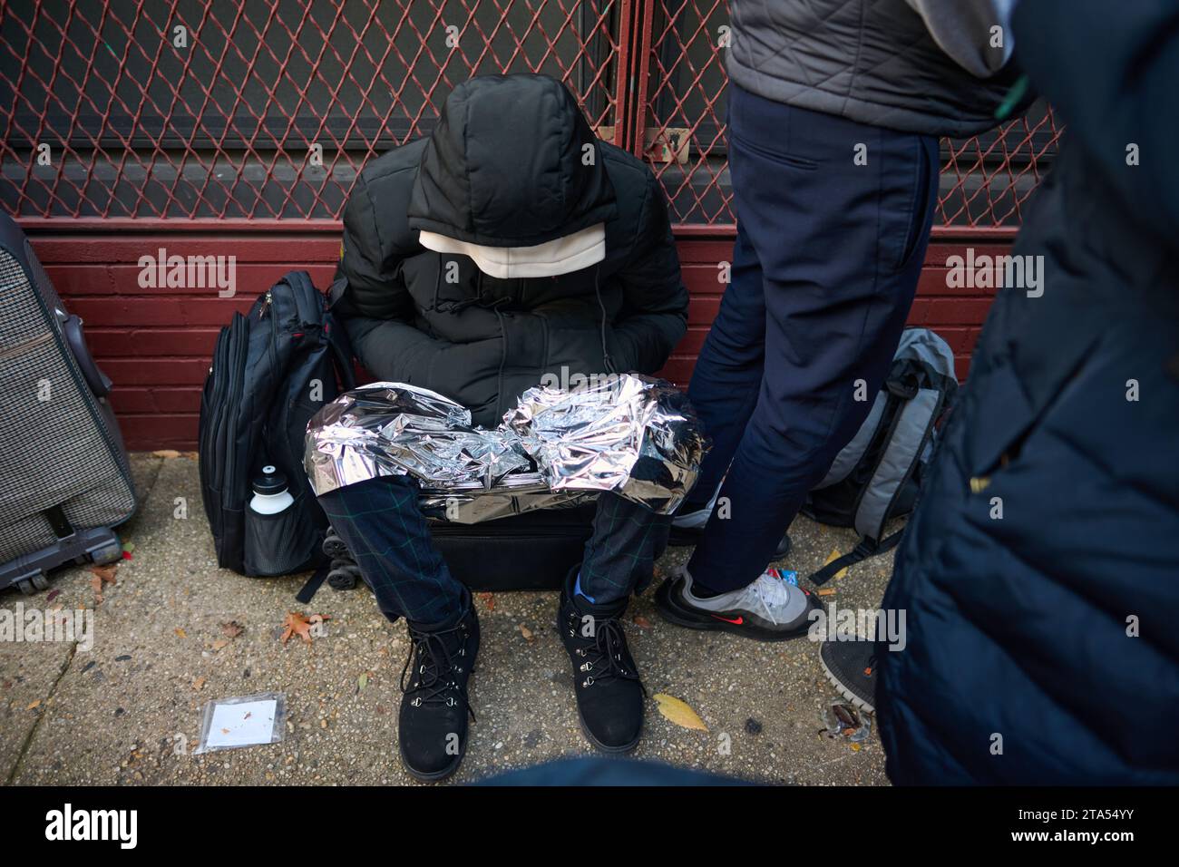 New York, New York, USA. November 2023. Migranten warten 10 Stunden lang draußen in der Kälte, um in eine ehemalige Schule im East Village zu gelangen, die als Einwanderungszentrum genutzt wird, in dem Migranten nach Ablauf der 30-tägigen Wohndauer wieder eine Wohnung beantragen müssen. (Kreditbild: © Edna Leshowitz/ZUMA Press Wire) NUR REDAKTIONELLE VERWENDUNG! Nicht für kommerzielle ZWECKE! Stockfoto