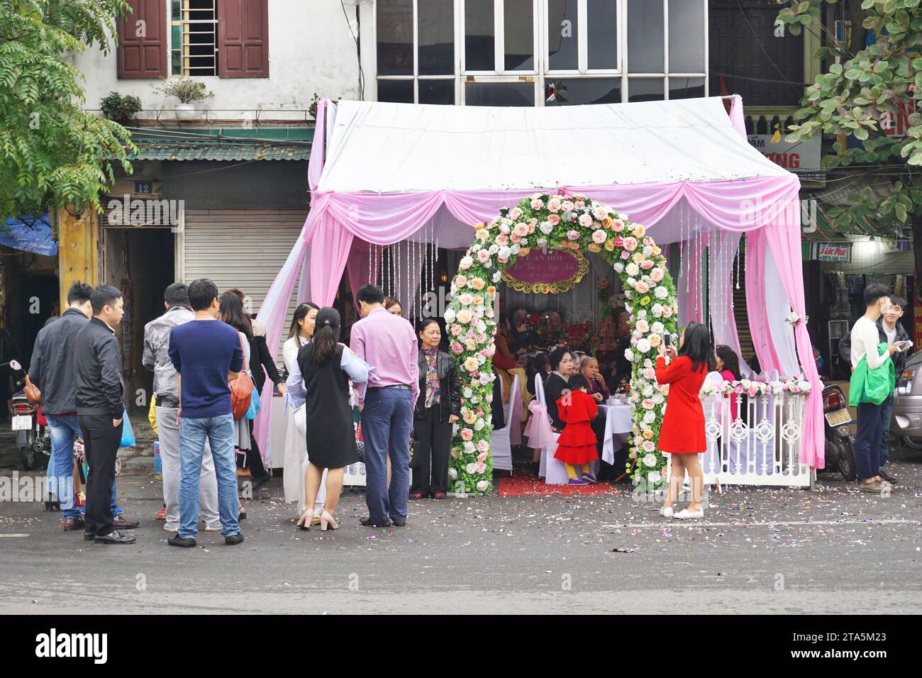 Ein temporäres Baldachin für eine Hochzeitsfeier vor einem Haus, das den gesamten Bürgersteig und eine Spur der Straße in Hanoi, Vietnam, blockiert Stockfoto