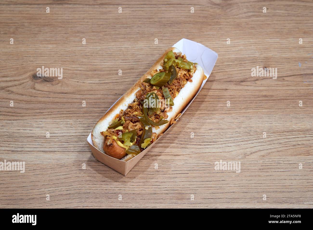 Spezieller Hotdog in Bastelbox auf Holztisch Stockfoto