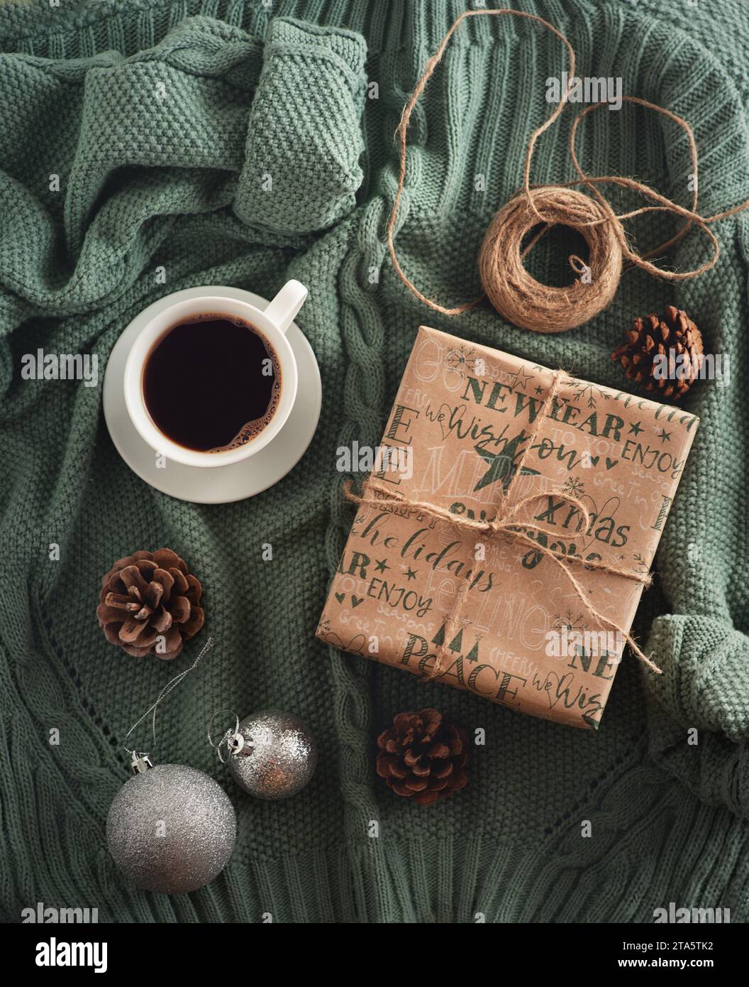 Festliches Set auf einem Pullover mit einem Neujahrsgeschenk und Kaffee, Blick von oben Stockfoto
