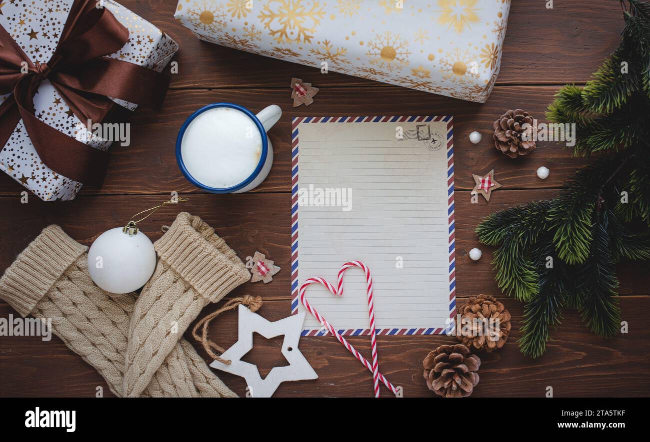 Draufsicht auf ein Notizbuch mit Weihnachtsgeschenken und Weihnachtsdekorationen auf hölzernem Hintergrund. Hintergrund des Weihnachtskonzerts Stockfoto