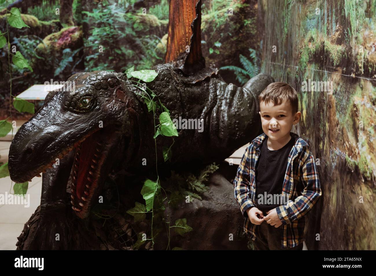 Ein Junge neben einem Dinosaurier auf der Ausstellung Stockfoto