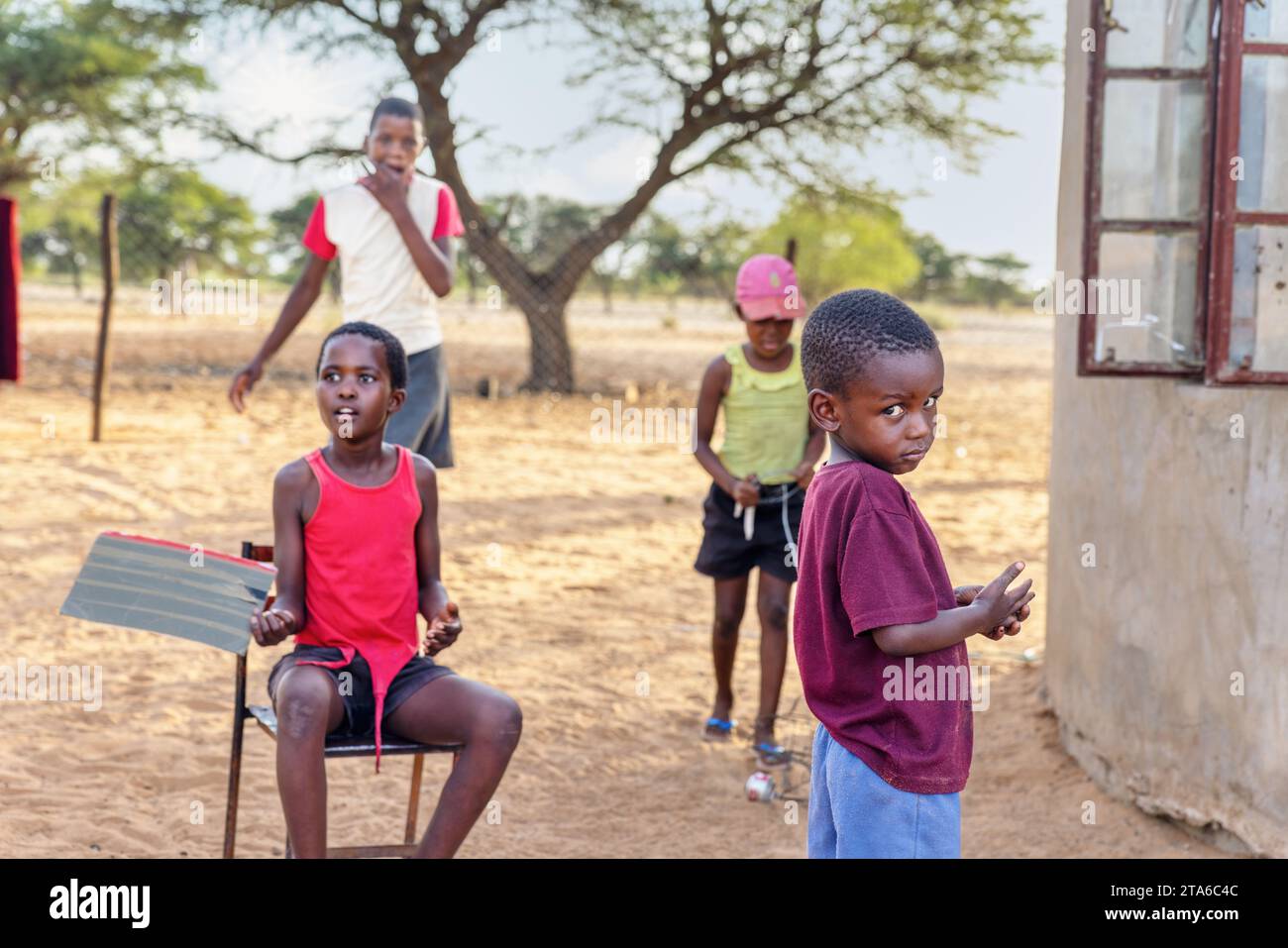 Gruppe afrikanischer Dorfkinder, die im Hof spielen Stockfoto