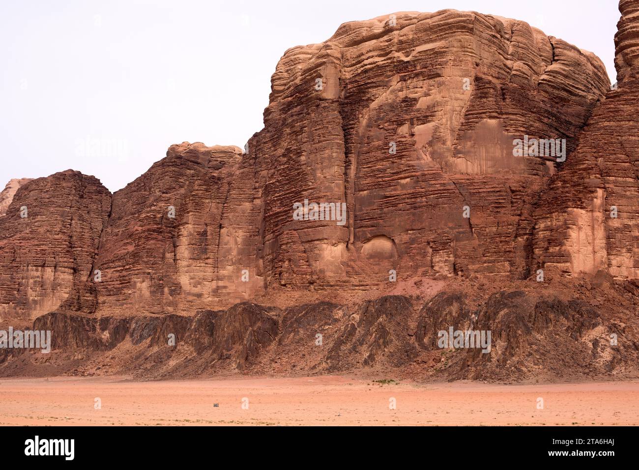 Wadi Rum oder Tal des Mondes (UNESCO-Weltkulturerbe). Sandsteinberg auf magmatischem Fels (schwarz). Jordanien. Stockfoto