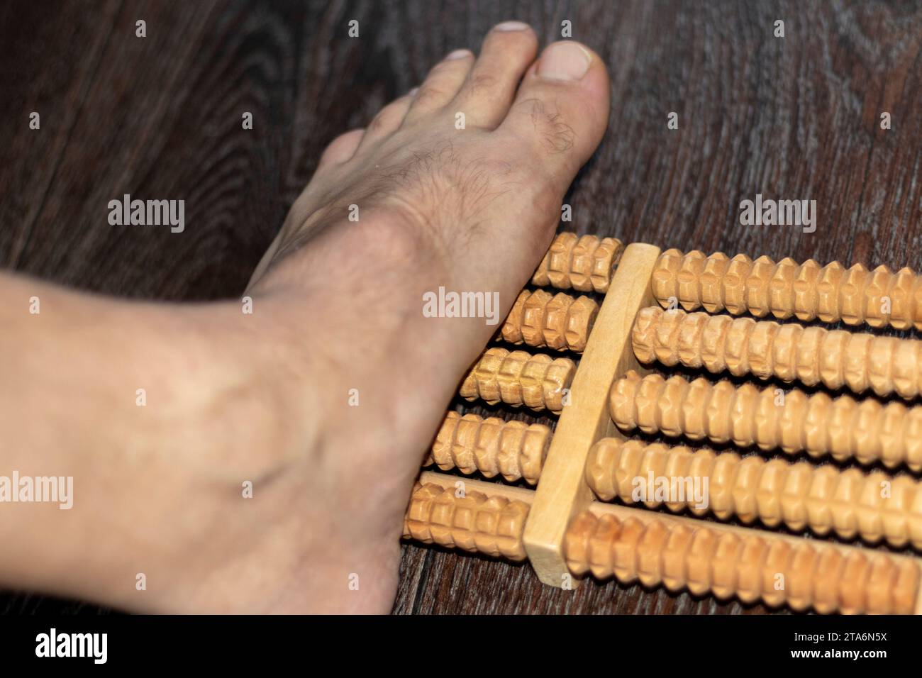 Aufnahme des Mannes mit Fußmassagegerät zur Verbesserung des Plattfußes Stockfoto