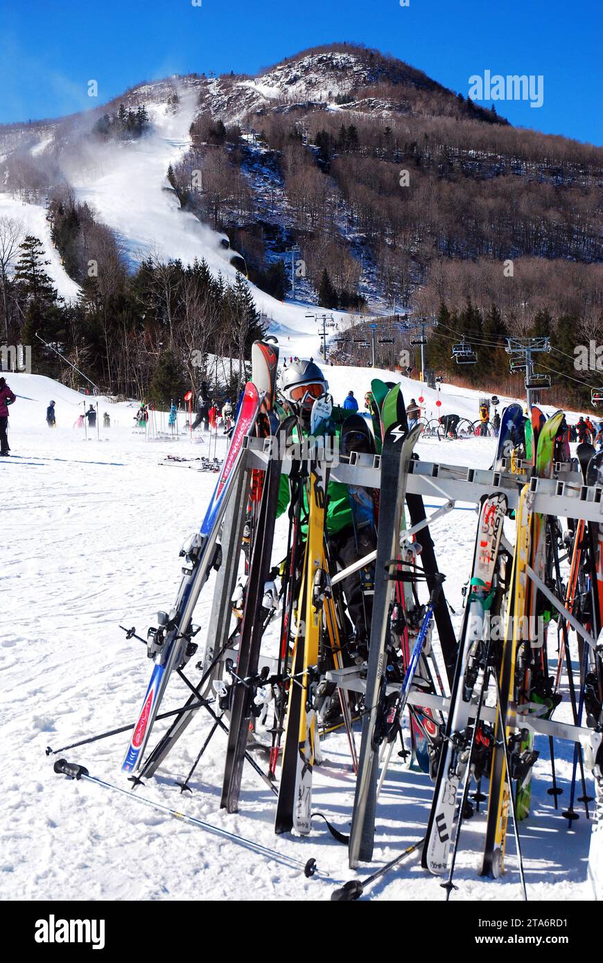 Die Skifahrer legen ihre Ski an einem kalten Wintertag in einer Pause von der Piste auf die Piste am Fuße eines Berges Stockfoto