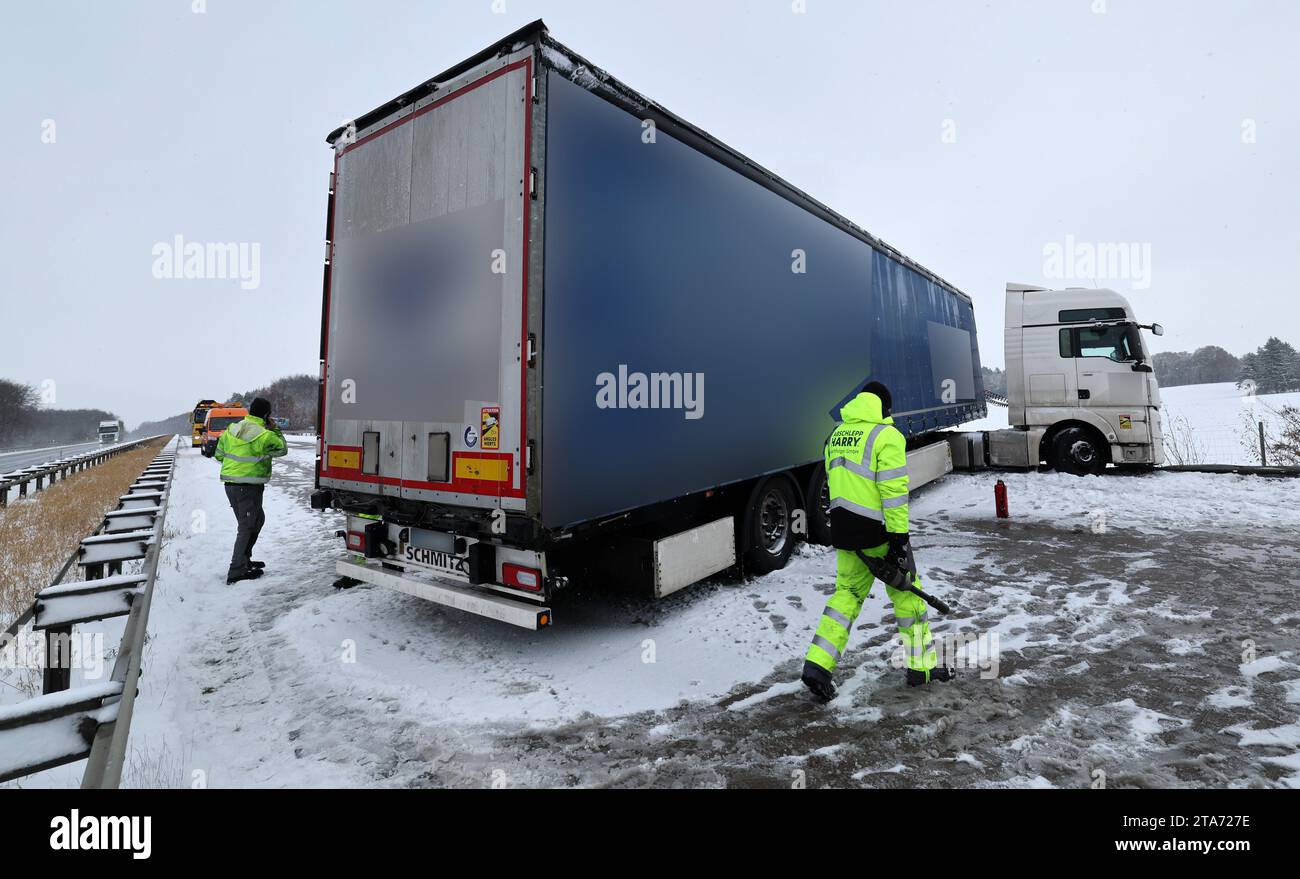 Laage, Deutschland. November 2023. Ein auf einer rutschigen Straße ausgerutschter Lkw steht auf der Autobahn A19 Rostock - Berlin in Richtung Rostock. Die Autobahn musste für den Bergungsbetrieb mehrere Stunden gesperrt werden. Der Beginn des Winters im Nordosten hat an vielen Orten chaotische Verkehrsbedingungen mit starkem Schneefall verursacht. Quelle: Bernd Wüstneck/dpa - ACHTUNG: Teile des Bildes sind aus rechtlichen Gründen pixelig/dpa/Alamy Live News Stockfoto