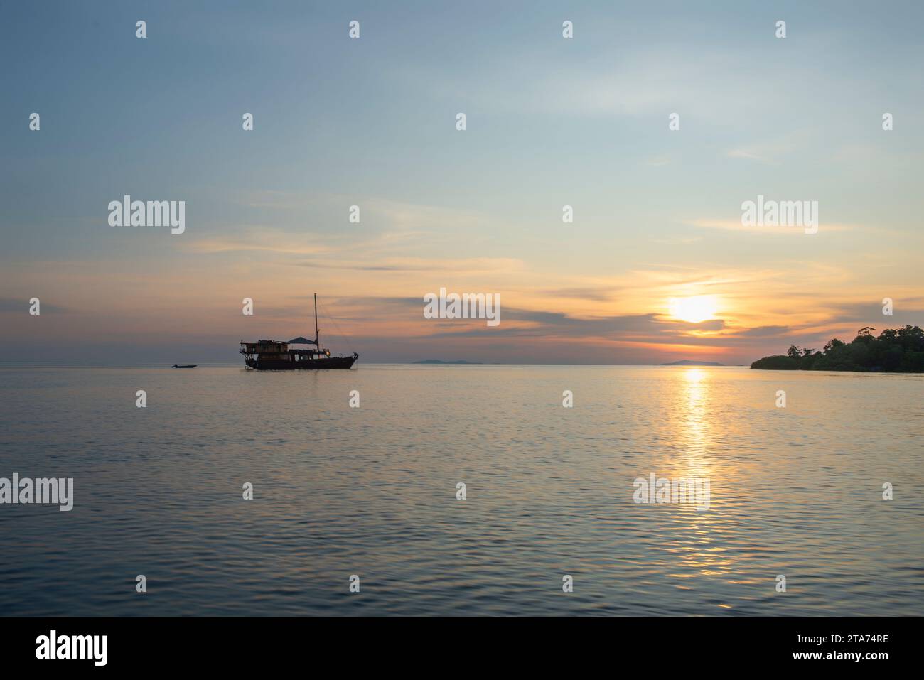 Silhouette eines Bootes, das bei Sonnenuntergang im Ozean verankert ist, Wayag, Raja Ampat, West Papua, Indonesien Stockfoto