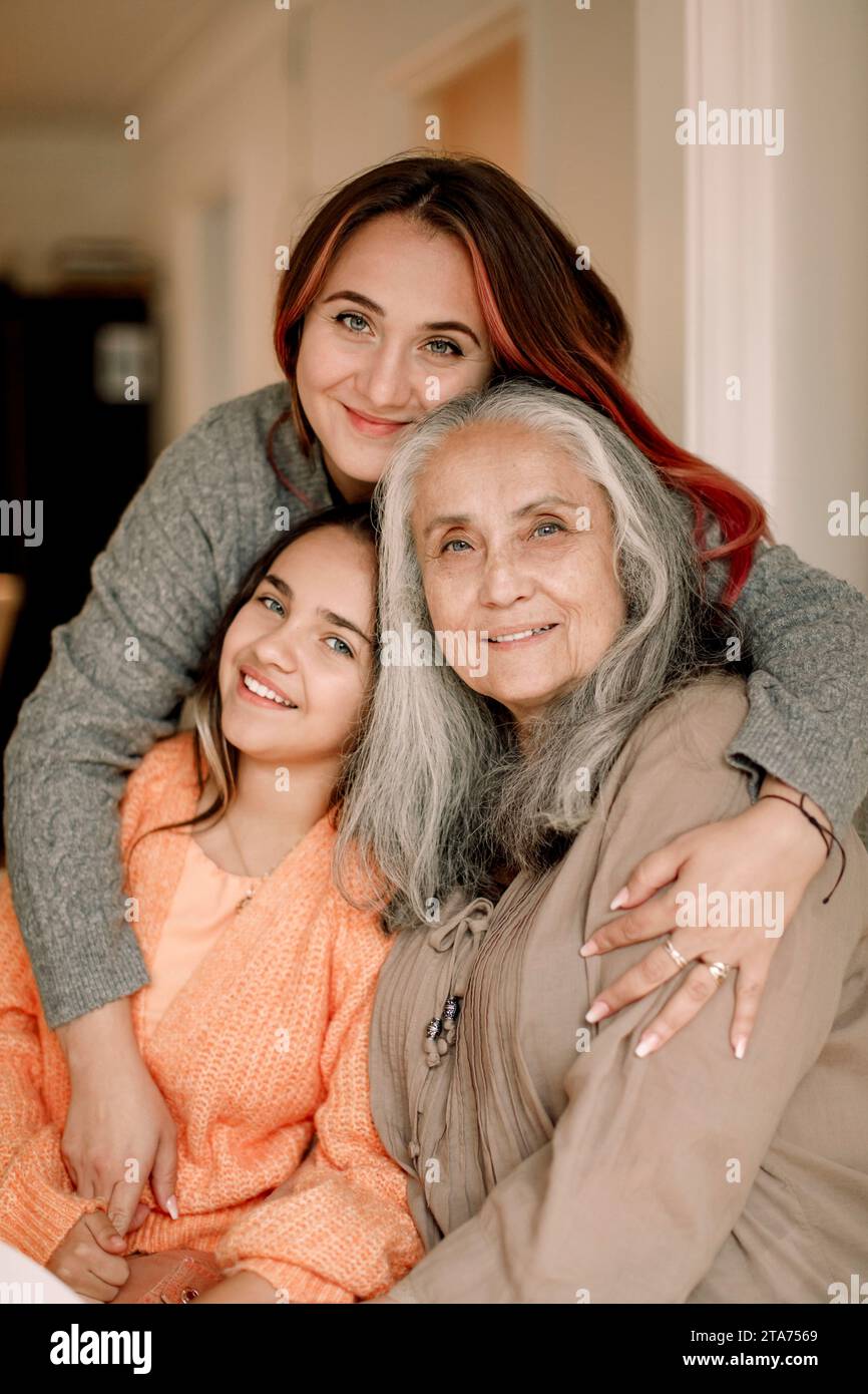 Porträt einer glücklichen Familie mehrerer Generationen, die sich zu Hause zusammenschließt Stockfoto