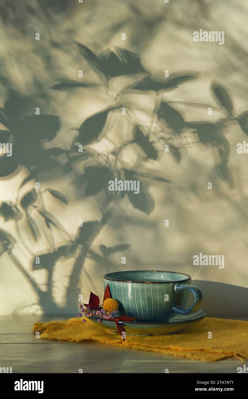 Abstrakter Herbst Schatten Zweige und Tasse Tee Stockfoto