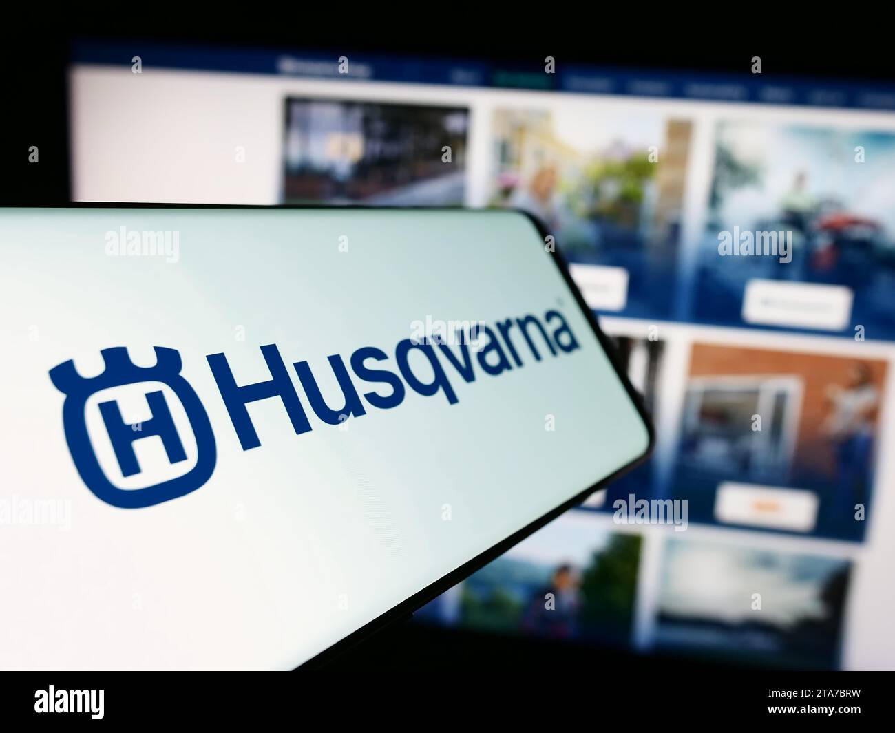 Mobiltelefon mit Logo des schwedischen Energieunternehmens Husqvarna ab vor der Business-Website. Fokussieren Sie sich auf die linke Mitte des Telefondisplays. Stockfoto