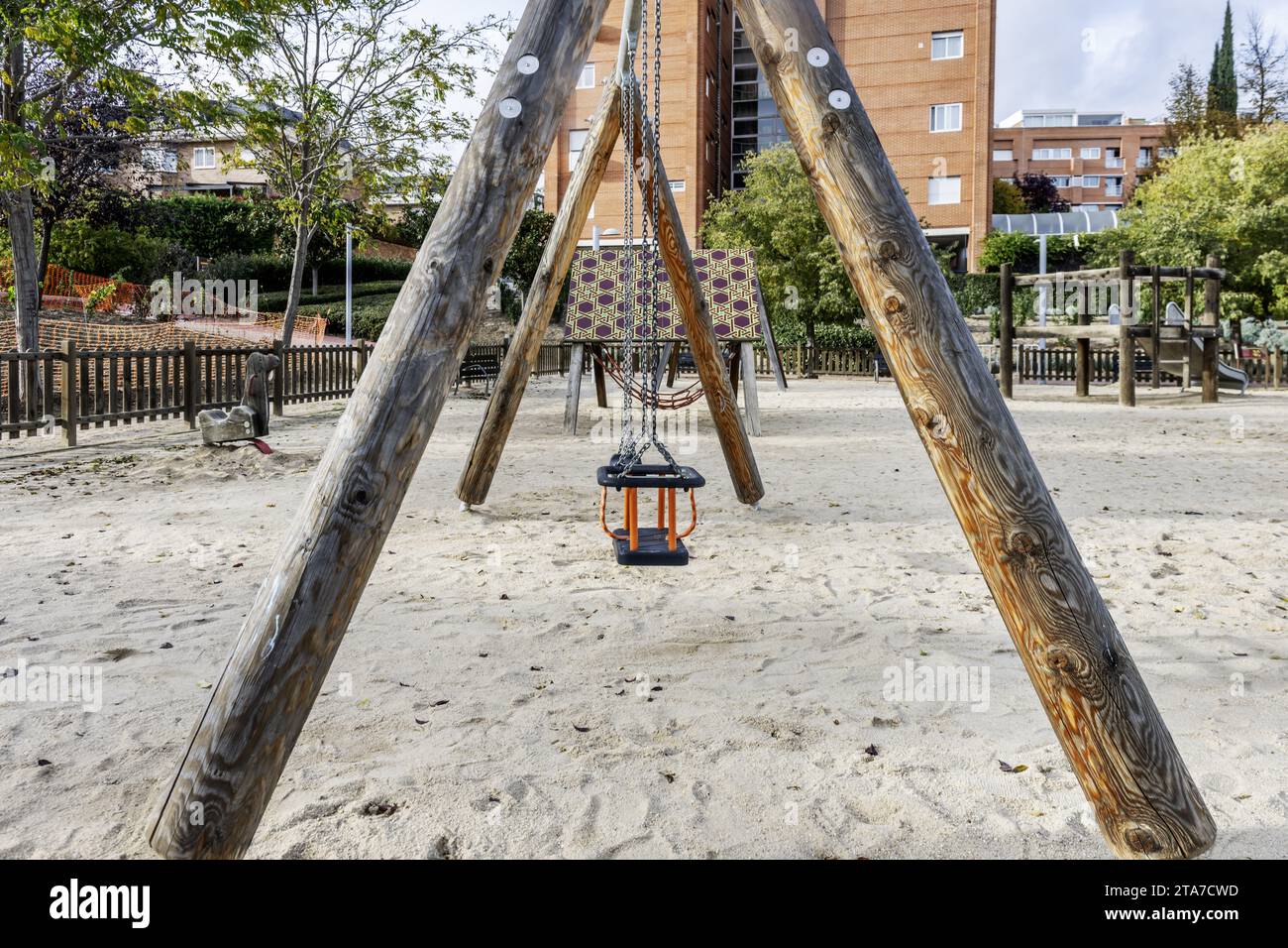 Ein städtischer Spielplatz mit Schaukeln und Rutschen auf einem Sandboden Stockfoto