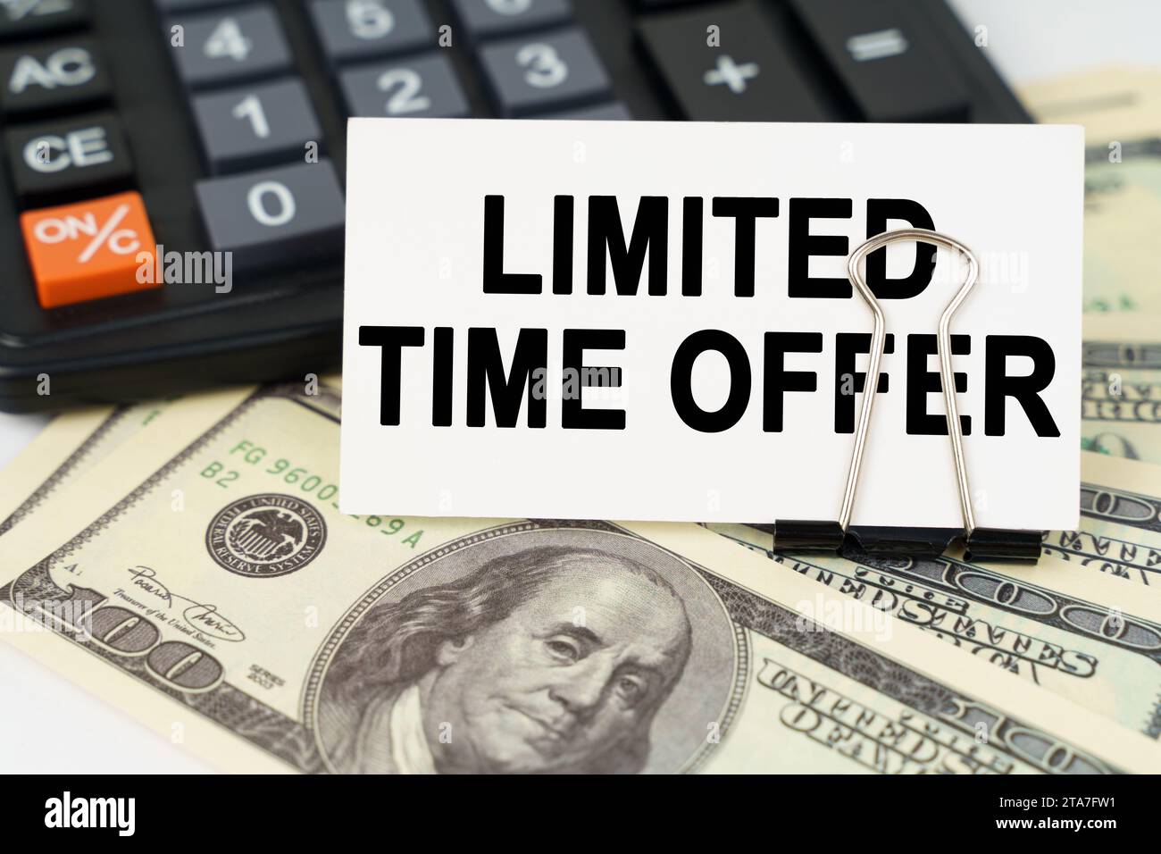 Geschäftskonzept. Auf den Dollars gibt es einen Taschenrechner und eine Visitenkarte mit der Aufschrift - ZEITLICH BEGRENZTES ANGEBOT Stockfoto