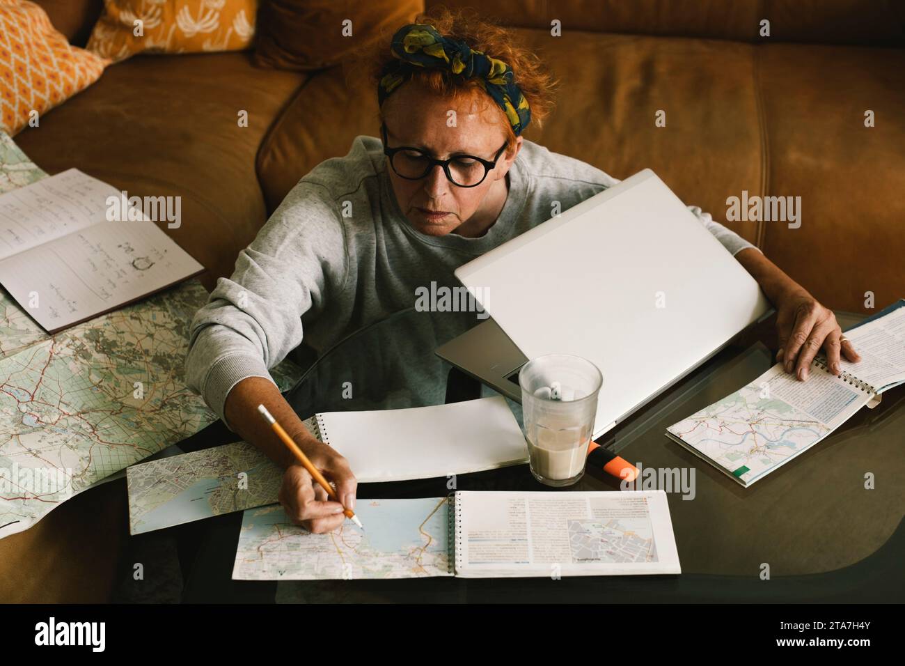 Hochwinkelansicht einer Seniorin, die zu Hause eine Reise plant Stockfoto