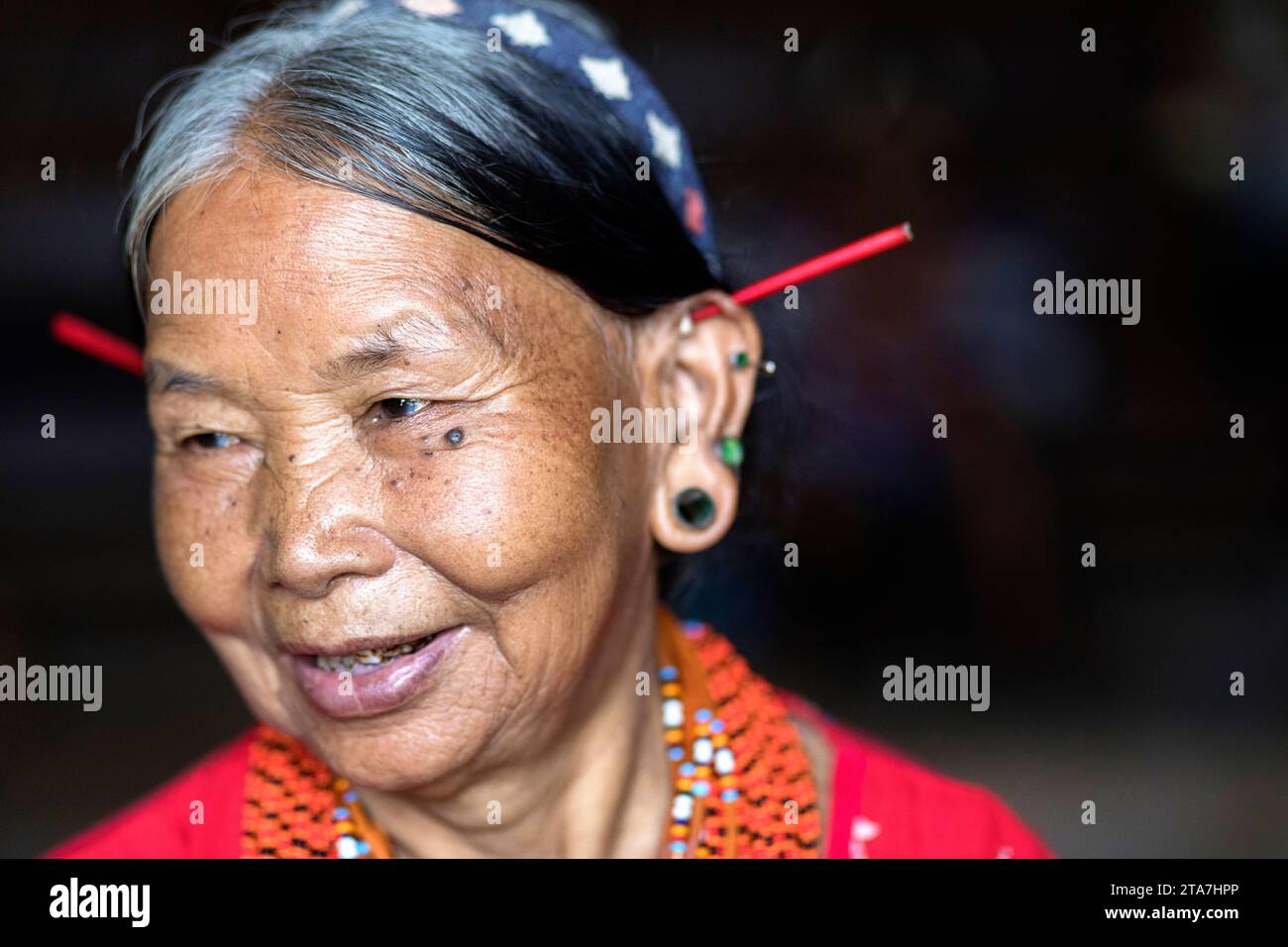 Die Frau des traditionellen Königs des Konyak-Stammes, auch Angh genannt, trägt aufwendige Perlenhalsketten und Stammesornamente in einem abgelegenen Dorf in Indien. Stockfoto