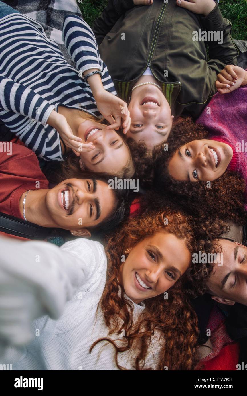 Direkt über dem Blick auf fröhliche Teenager-Freunde, die im Park liegen Stockfoto