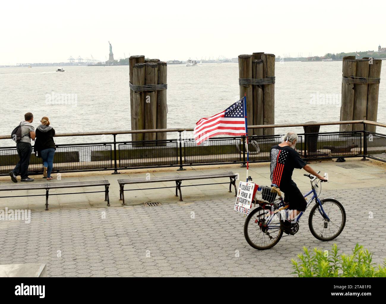 New York, USA - 28. Mai 2018: Ein Mann mit US-Flagge auf einem Fahrrad im Battery Park in New York. Stockfoto
