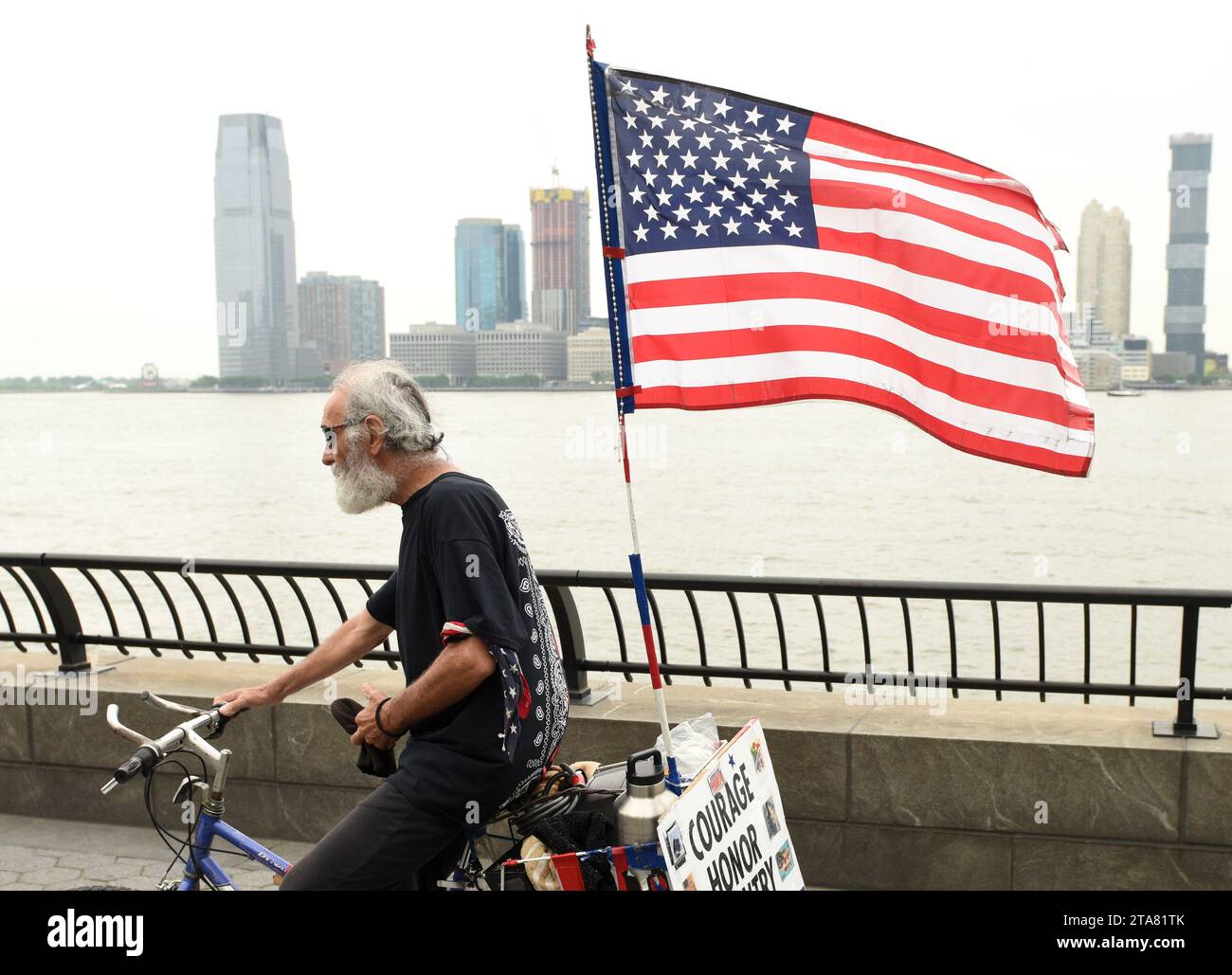 New York, USA - 28. Mai 2018: Ein Mann mit US-Flagge auf einem Fahrrad in der Battery Park City Esplanade in New York. Stockfoto