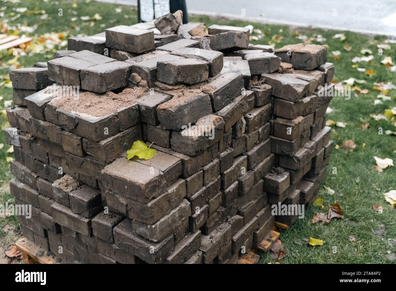 Rostig und verrostet ein Haufen verwitterter und rostiger Pflasterplatten, die während der Renovierung der Straße aufgestapelt wurden und Anzeichen von Abnutzung zeigen, mit Rissen und Spuren Stockfoto