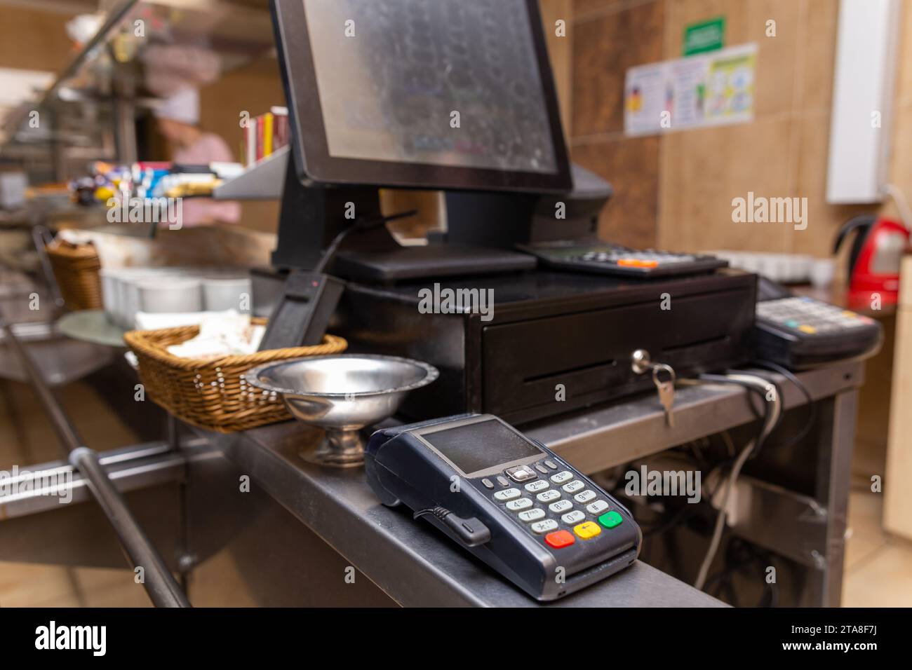 Kasse zur Bezahlung von Einkäufen in einem Café mit digitalem Terminal. Verkäuferarbeitsplatz im Café. Zahlungsverkehr über mobile und drahtlose NFC Stockfoto