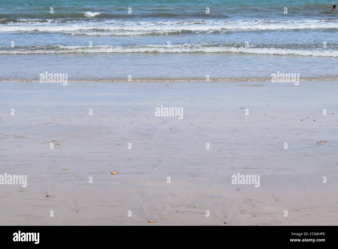 Nicht bearbeitetes Foto von friedlichem Wasserhorizont und Sandzusammensetzung. Nützlicher Sommerhintergrund mit Sandstrand mit Wasserrand Stockfoto