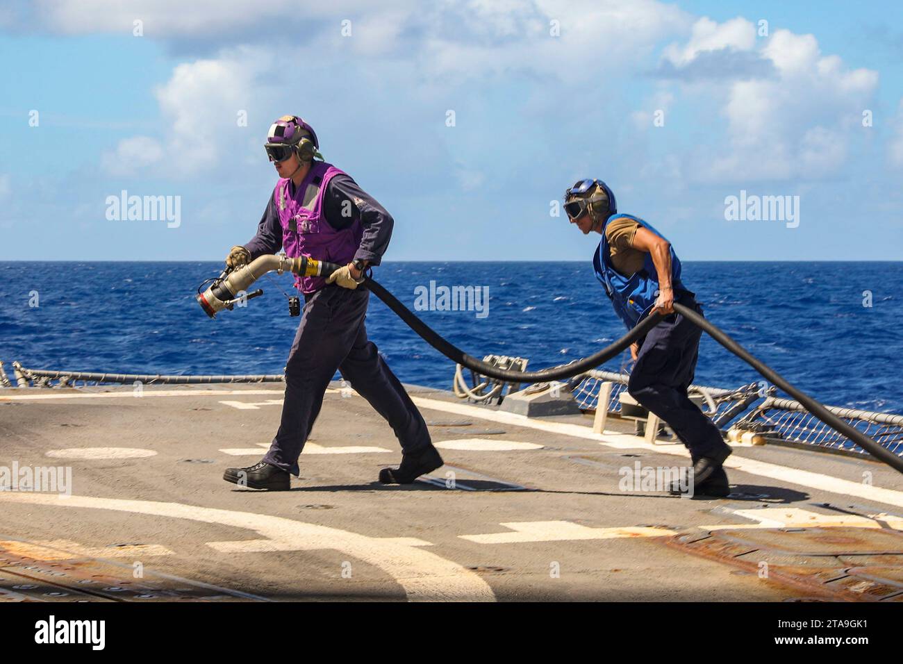 Philippinische See. November 2023. Gasturbinensystemtechniker (Elektrik) 2. Klasse Christopher Smart, links, aus Montrose, Colorado, und Seaman Cesar Bojorquez aus Oxnard, Kalifornien, bereiten sich darauf vor, einen MH-60R Sea Hawk zu tanken, der an die Warlords of Helicopter Maritime Strike Squadron (HSM) 51 angeschlossen ist, auf dem Flugdeck des Arleigh Burke-Klasse-Raketenzerstörers USS Shoup (DDG 86), während er Routineoperationen in der Philippinischen See durchführt. Shoup ist Commander, Task Force (CTF) 71/Destroyer Squadron (DESRON) 15, der größten DESRON der Marine und der DESRON Stockfoto