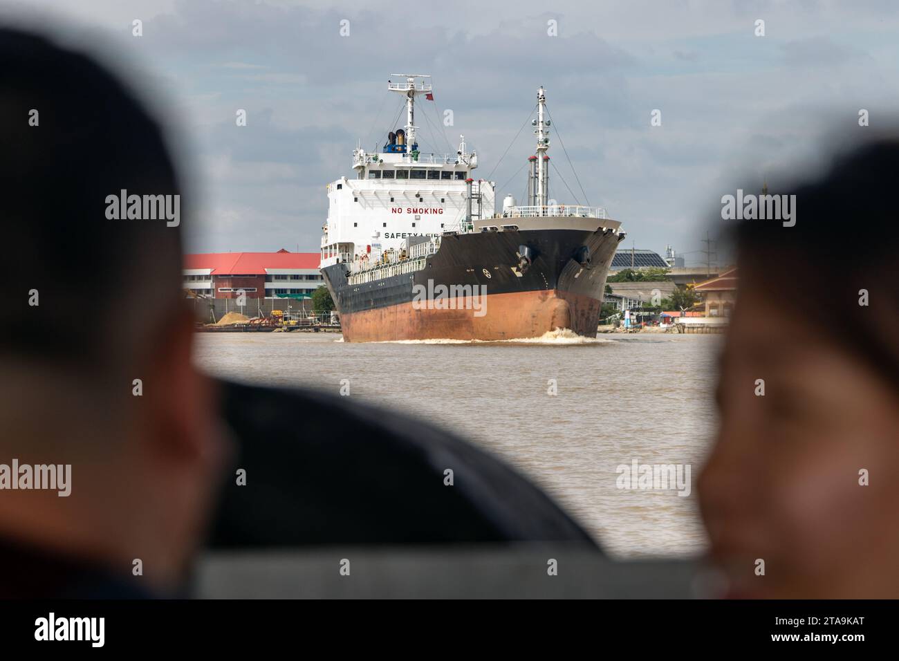Ein Öltanker fährt an der Fähre mit Passagieren an der Mündung des Chao Phraya Flusses, Bangkok, Thailand Stockfoto