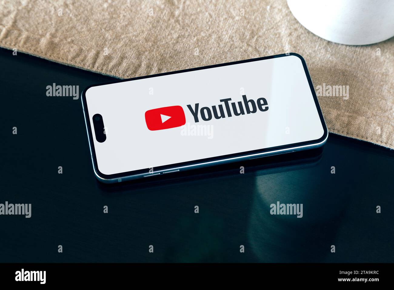 YouTube-App auf dem Smartphone auf einem Tisch zu Hause. Video-Streaming-Anwendung auf dem Bildschirm des Mobiltelefons. Stockfoto