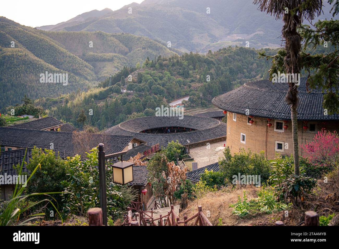 Chinesisches Fujian Tulou und die umliegende Landschaft während des Sonnenuntergangs. Es wurde zum UNESCO-Weltkulturerbe erklärt. Ein berühmtes historisches Relikt. Stockfoto Chinesisches Fujian Tulou und die umliegende Landschaft während des Sonnenuntergangs. Es wurde zum UNESCO-Weltkulturerbe erklärt. Ein berühmtes historisches Relikt. Stockfoto