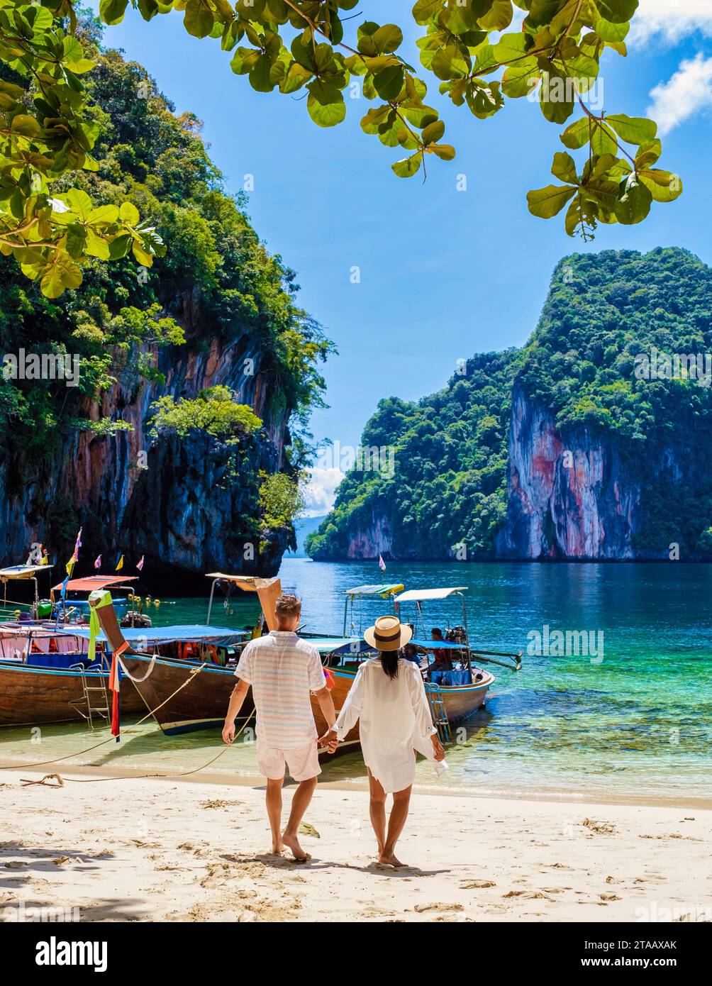 Männer und Frauen in der tropischen Lagune von Koh Loa Lading Krabi Thailand Teil der Koh Hong Islands in Thailand. Wunderschöner Strand mit Kalksteinklippen und Longtail-Booten an einem sonnigen Tag Stockfoto