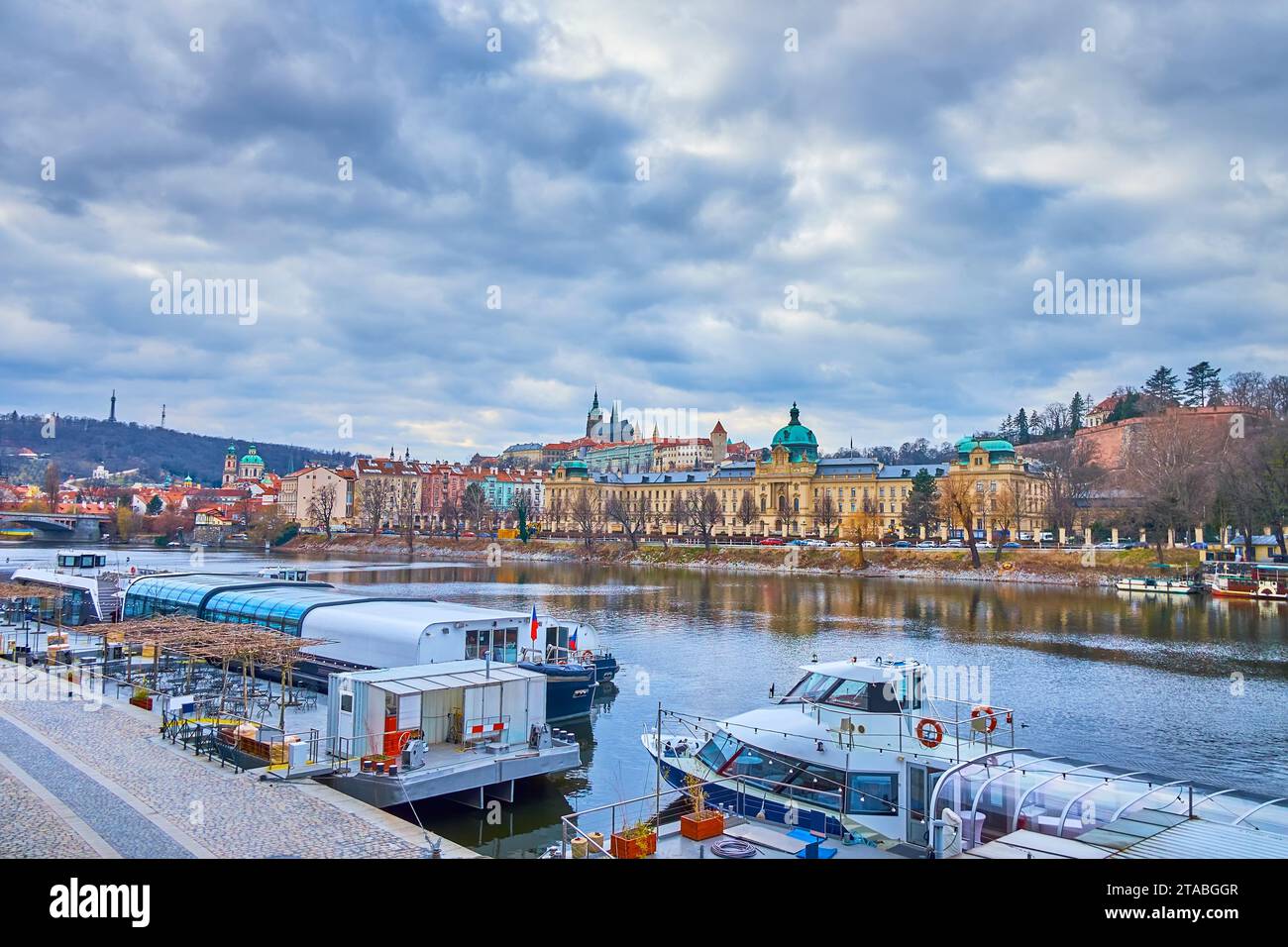 Moldau mit vertäuten Schiffen und Straka Academy am gegenüberliegenden Flussufer, Prag, Tschechien Stockfoto