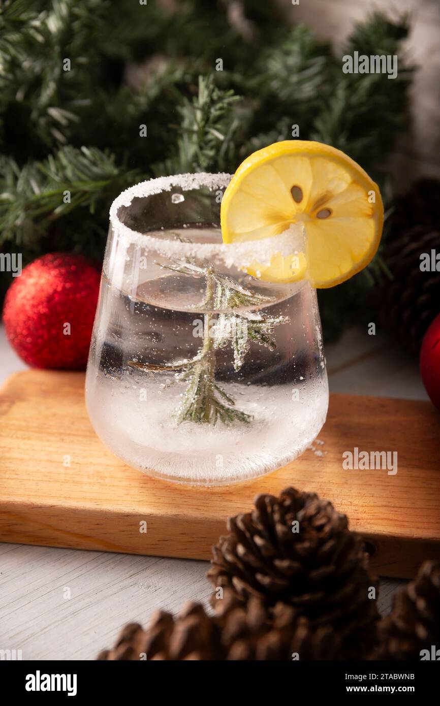 Schneekugel-Cocktail. Weihnachtsgetränk, kreatives Festgetränk im Glas, dekoriert mit Rosmarinzweig wie eine weihnachtskiefer und Zitrus sli Stockfoto