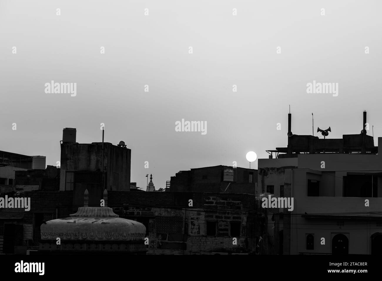 Überfüllte Stadthäuser blicken bei Sonnenuntergang in der Abenddämmerung aus einem flachen Winkel in Schwarz-weiß Stockfoto