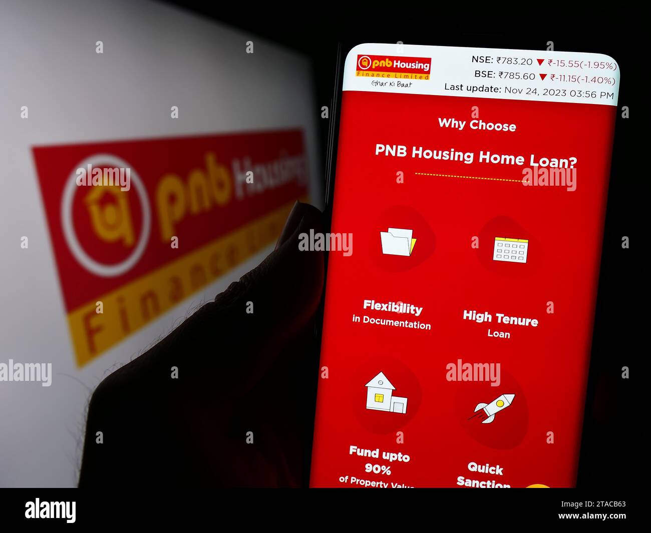 Person, die ein Handy hält, mit Webseite des indischen Finanzunternehmens PNB Housing Finance Limited vor dem Logo. Konzentrieren Sie sich auf die Mitte des Telefondisplays. Stockfoto