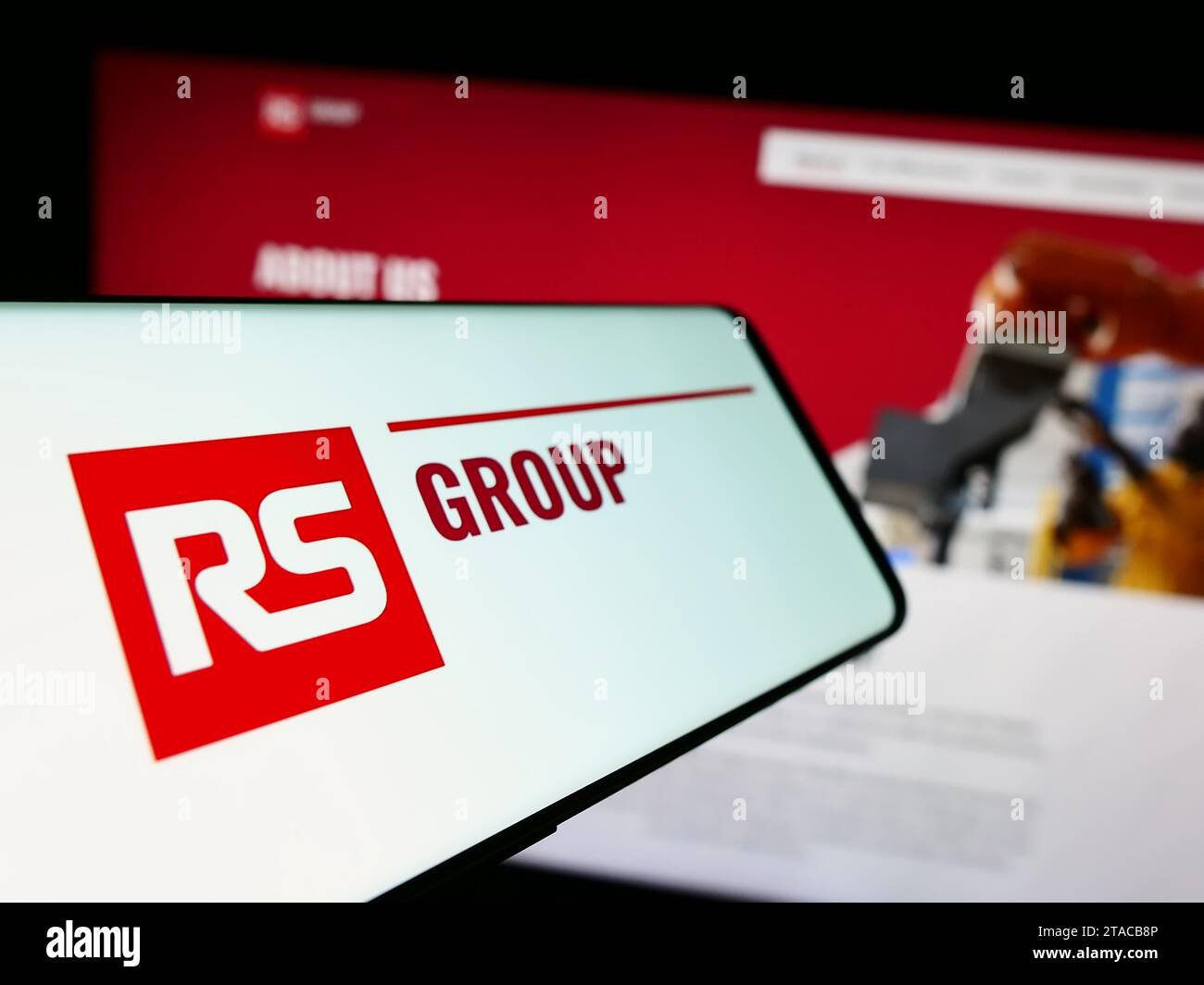Smartphone mit Logo des britischen Stromverteilers RS Group plc vor der Business-Website. Fokussieren Sie sich auf die linke Mitte des Telefondisplays. Stockfoto
