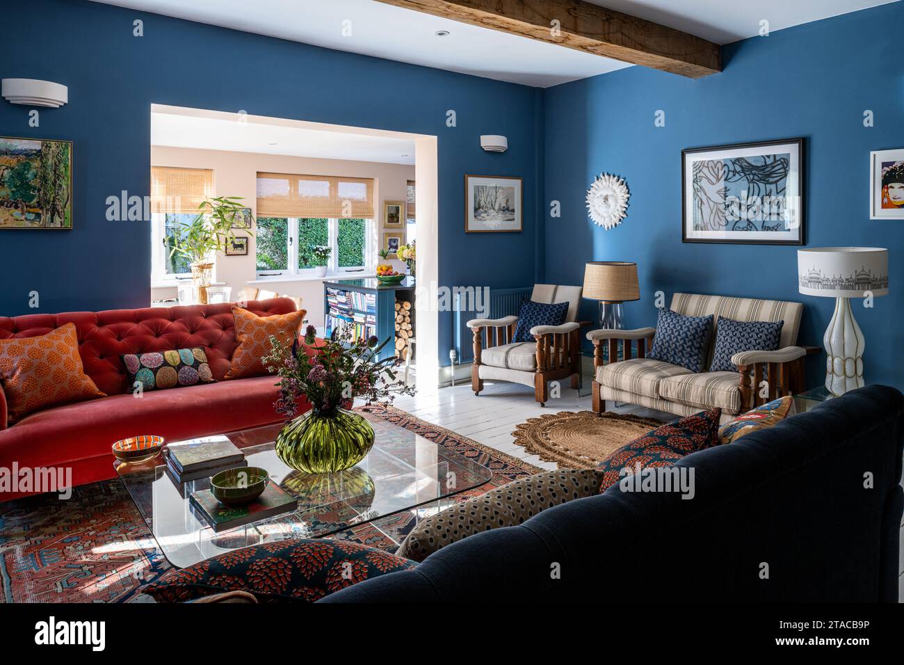 Wohnzimmer in „Bamiyan Blue“ mit leuchtenden orangefarbenen Kontrasten im Stil der 1930er Jahre. Hove, East Sussex, Großbritannien. Stockfoto