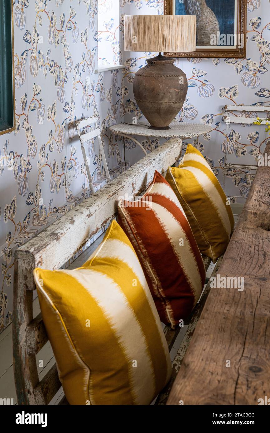 Sitzbank und Lampe aus lokalem Anbau mit „Kürbis“-Tapete von Eloise Home. Haus im Stil der 1930er Jahre im Arts and Crafts Stil. Hove, East Sussex, Großbritannien. Stockfoto