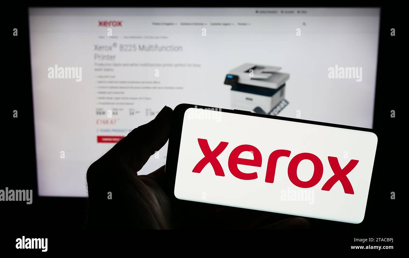 Person, die das Smartphone mit dem Logo des US-Druckerunternehmens Xerox Holdings Corporation vor der Website hält. Schwerpunkt auf dem Display des Telefons. Stockfoto