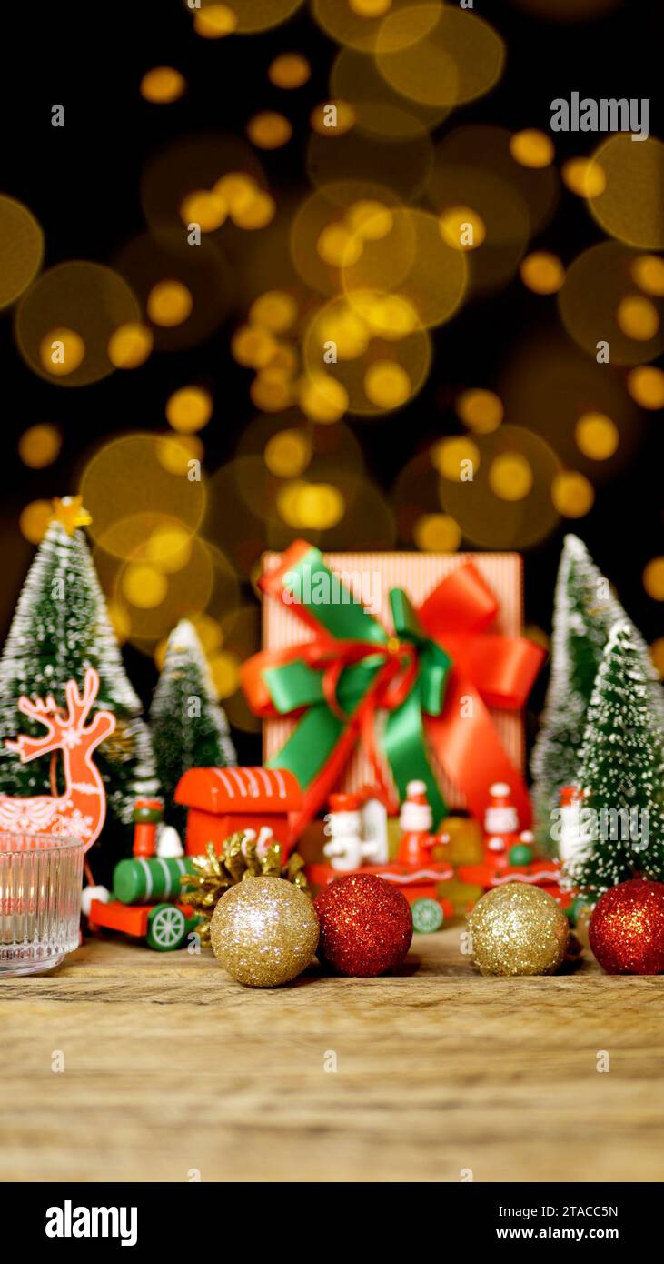Weihnachtsgeschenkbox Geschenk mit rotem grünem Band auf Holztisch mit Weihnachtsschmuck Dekoration während der Weihnachtsgrüße mit Kopierraum Stockfoto