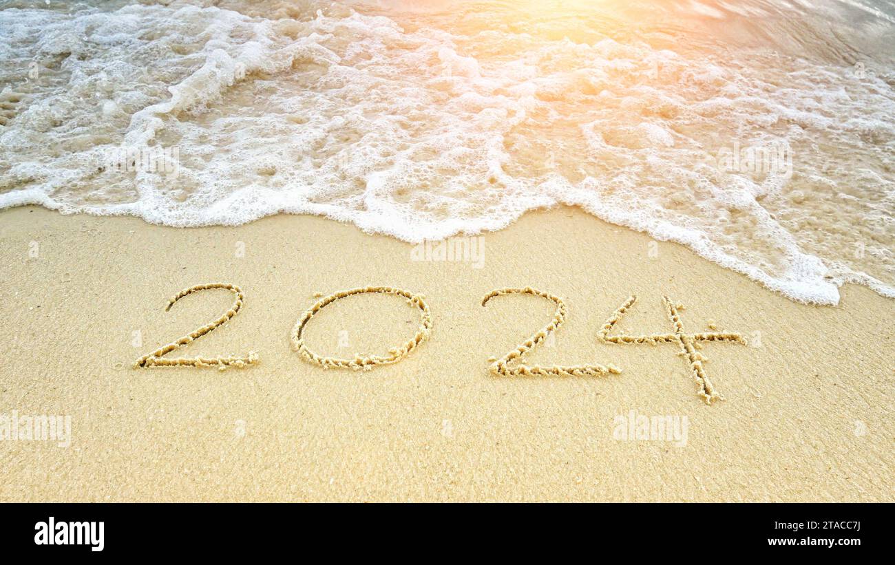 Frohes neues Jahr 2024. Nummer 2024 schreibt am Sandstrand mit Wellen, Wellen, die mit weißer Blase spritzen. Zum Jahr 2024 Stockfoto